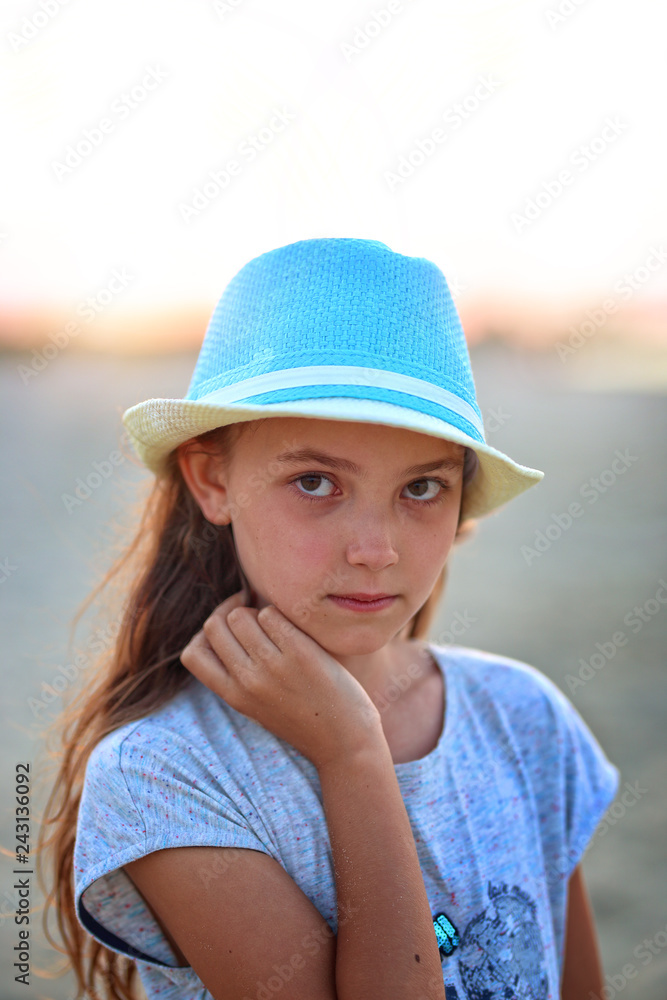 young girl in a hat on a sunny day at the beach