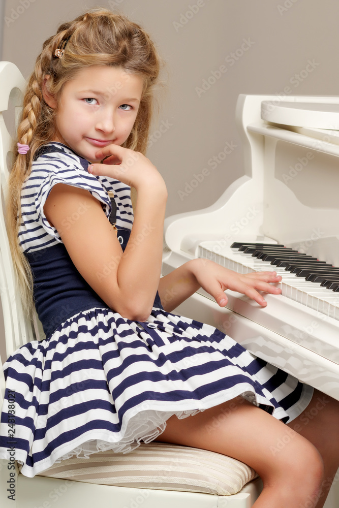 The girl is at the white grand piano. The girl is at the white grand piano.