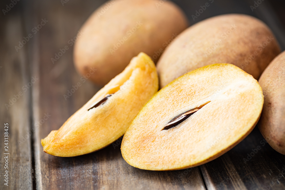 Sapodilla plum fruit on wooden table, exotic Thai fruit (La mood) Sapodilla plum fruit on wooden table, exotic Thai fruit (La mood)
