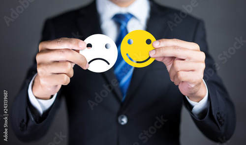 Businessmen holding a face icon facial expressions negative or positive, happy face or sad face, like or dislike, Customer service experience and satisfaction survey concepts.