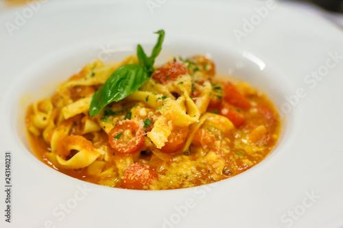 Penne pasta bolognese cheese in tomato sauce with onion, tomato, decorated with basil leave