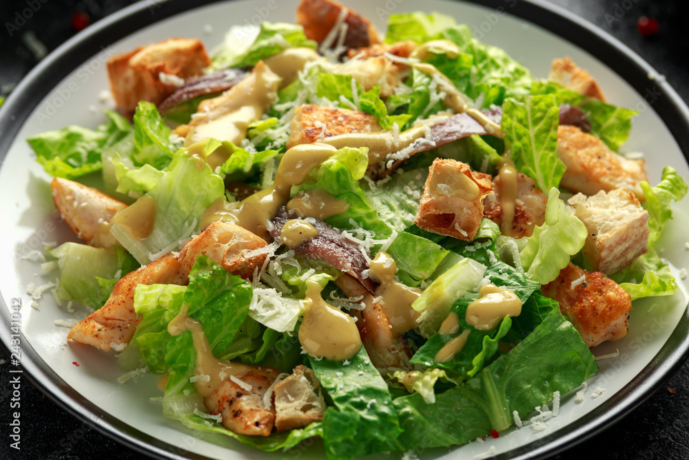 Caesar salad with chicken, anchous fish, croutons, parmesan cheese and greens. healthy food