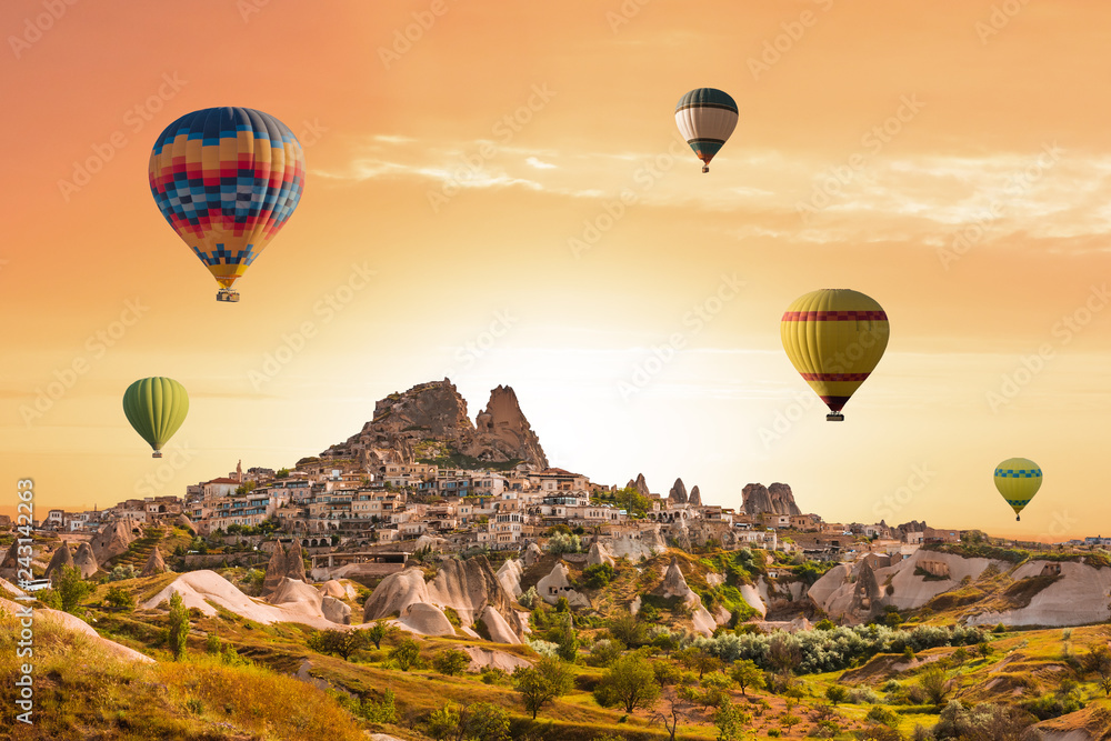 Fototapeta premium Colorful hot air balloons flying over the valley at Cappadocia, Uchisar, Turkey. Volcanic mountains in Goreme national park