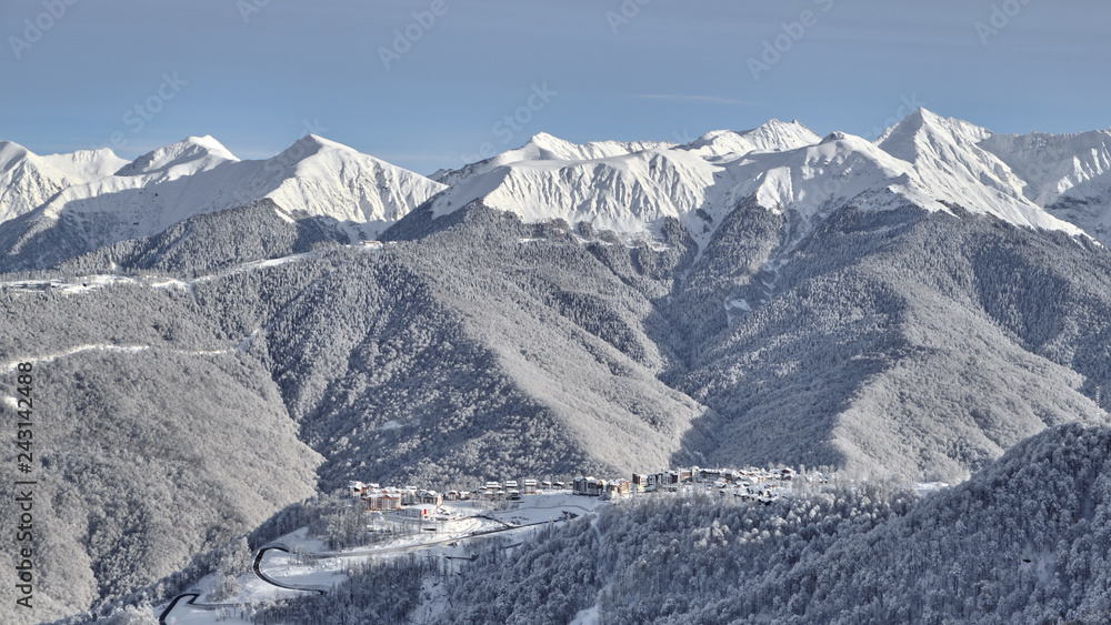 Panoramic view of the mountains and the village of Krasnaya Polyana. Aerial photography with copter. Esto-Sadok. Sochi. ski resort. Nature, snow, skiing, snowboarding.