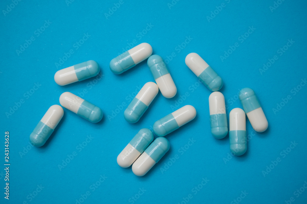 closeup of blue capsules on blue background closeup of blue capsules on blue background