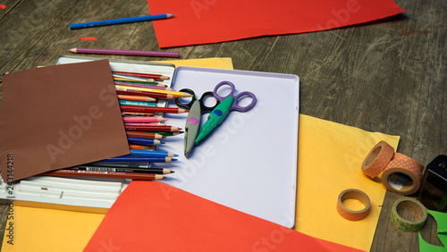 Bastel Utensilien für Kinder, Schere, Buntstifte, Papier auf Holztisch