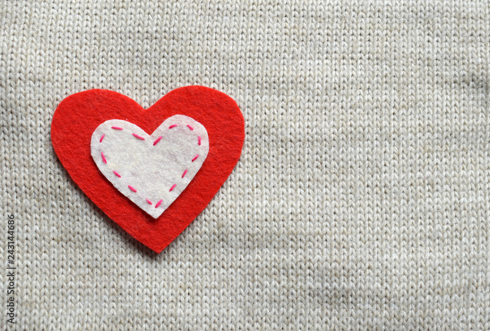 Felt hearts on knitted texture. Valentines Day background or greeting card concept.