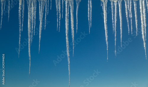 Icicles hanging in front of blue sky