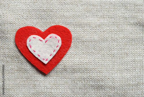 Felt hearts on knitted texture. Valentines Day background or greeting card concept.