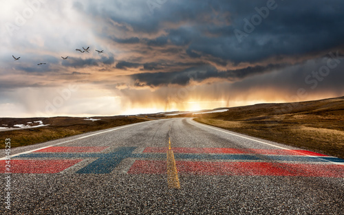 Straße mit Flagge und Regenwolken am Nordkapp in Norwegen