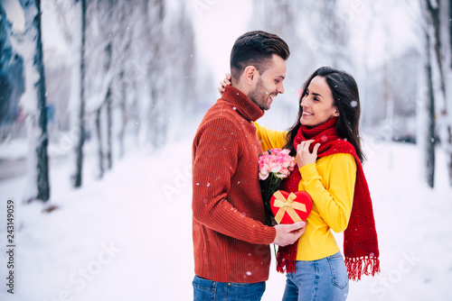 Surprise with love in Valentines day. Handsome young man gives present in holidays for his beautiful girlfriend