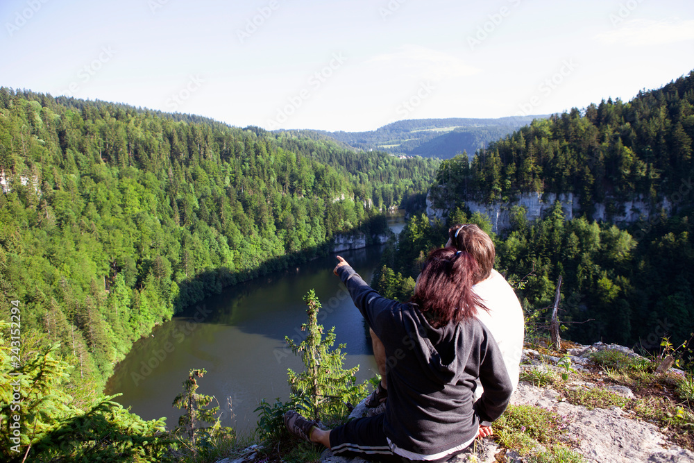 Couple enjoying breathtaking landscape from top of a cliff Couple enjoying breathtaking landscape from top of a cliff