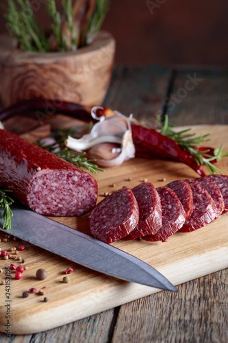 Smoked salami on a old wooden table. photo