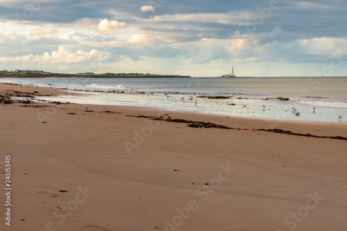 The Whitley Sands beach in Whitley Bay, Tyne And Wear, England, UK - looking north towards St. Mary's Lighthouse