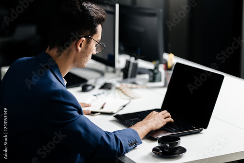 Professional architect dressed  in a business suit works on the laptop in the office