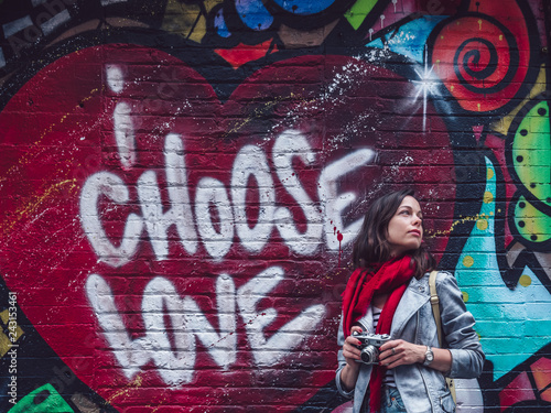 Young photographer by the wall with graffiti