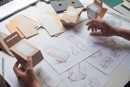 Designer sketching drawing design Brown craft cardboard paper product eco packaging mockup box development template package branding Label . designer studio concept . photo