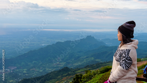 Woman tourist in a sweater dress watching the beautiful nature landscape of the forest and mountain during the sunrise at Phu Thap Boek Viewpoint Phetchabun, Thailand, 16:9 widescreen