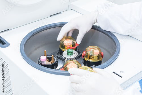 Bilde på lerret A scientist in sterile coverall gown placing cell culture flasks in the CO2 incubator