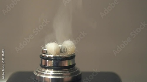atomizer of a regenerable electronic cigarette in operation. Steaming by heating the resistance with the wadding soaked in liquid causes a cloud of vapor photo