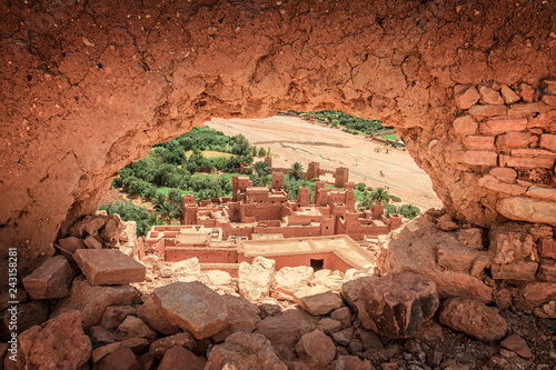 Popular point of view of the valley of the desolating river Onila through a hole in a wall of Ancient Kasbah in Ait-Ben-Haddou, Morocoo. Famous ancient berber kasbah. near Ouarzazate city in Morocco photo