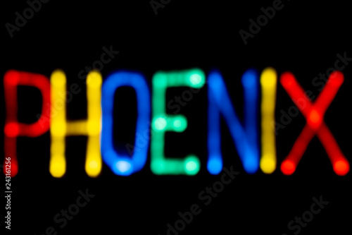 Light painting. City name. Phoenix. Blue, yellow, green and red colors. Black background.