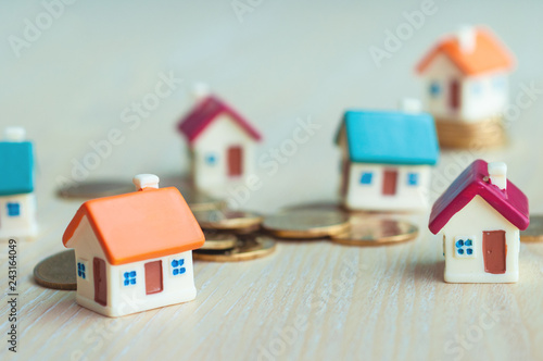Selective focus miniature small house with golden coins with copy space, real estate business investment, loan from a bank for housing.