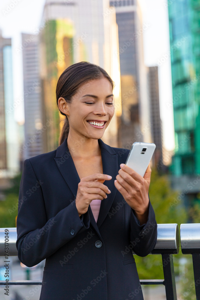 Woman using phone - Asian businesswoman holding smartphone texting on messenger app online to businesspeople. Working outside walking in city street. Happy Chinese Caucasian biracial lady. Woman using phone - Asian businesswoman holding smartphone texting on messenger app online to businesspeople. Working outside walking in city street. Happy Chinese Caucasian biracial lady.