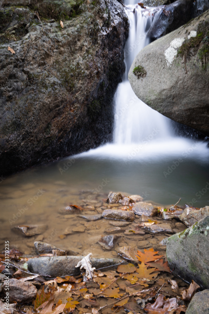 Fotografie beautiful forest waterfall creek in long exposure in fall scenery