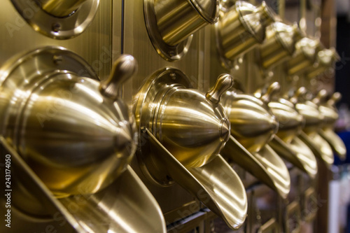 Close-up photo with selective focus of brass coffee bean dispensers in a Russian coffee shop