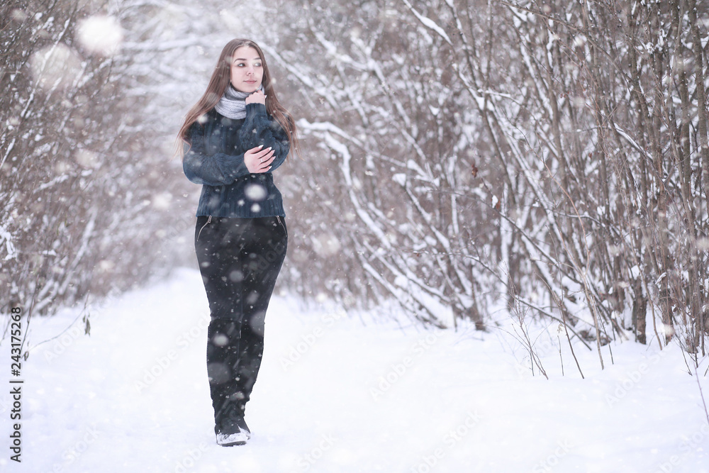 Girl in a winter park in snowfall Girl in a winter park in snowfall