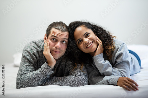 Smiling Young couple in grey sweater looking up.