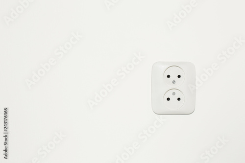 European power socket on an off white wall with copy space.