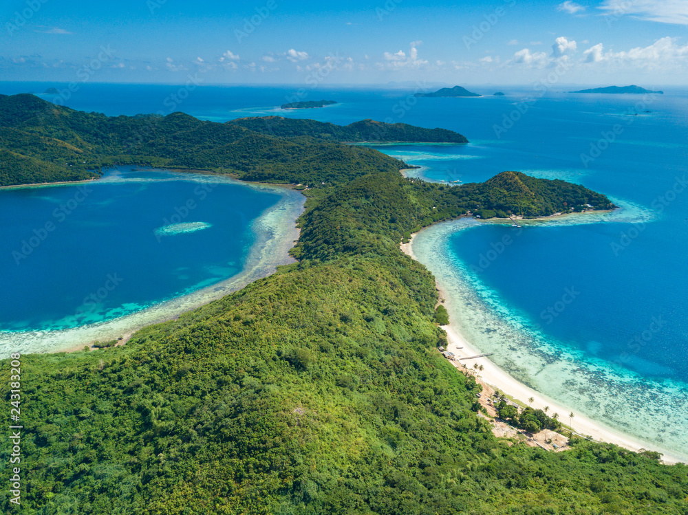 Aerial view of tropical island Bulalacao. Beautiful tropical island with white sandy beach, palm trees and green hills. Travel tropical concept. Palawan, Philippines