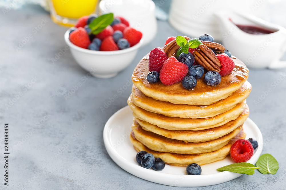 Stack of fluffy pancakes with fresh berries and pecan nuts Stack of fluffy pancakes with fresh berries and pecan nuts