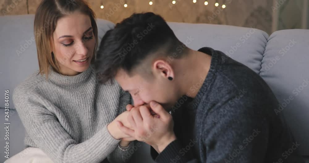 Love, relationship, young happy couple show their feelings together at home sitting on a cozy sofa in a living room Love, relationship, young happy couple show their feelings together at home sitting on a cozy sofa in a living room