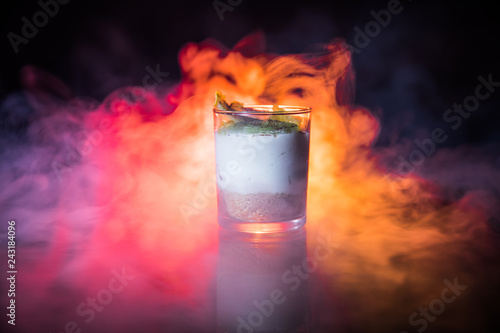 Sweet cheesecake in glass on a table with toned foggy backglight. photo