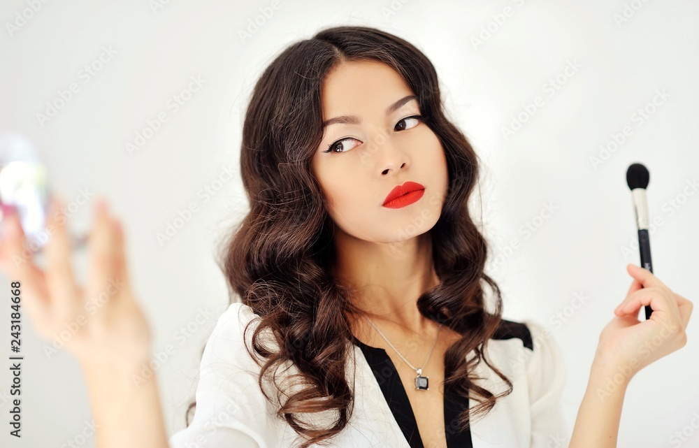 Young beautiful woman applying make-up
