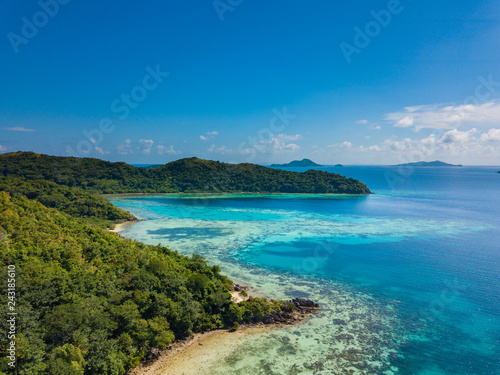 Aerial view of tropical beach of island Bulalacao. Beautiful tropical island with white sandy beach, palm trees and green hills. Travel tropical concept. Palawan, Philippines