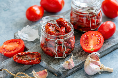 Sun dried tomatoes with herbs and olive oil in jar.