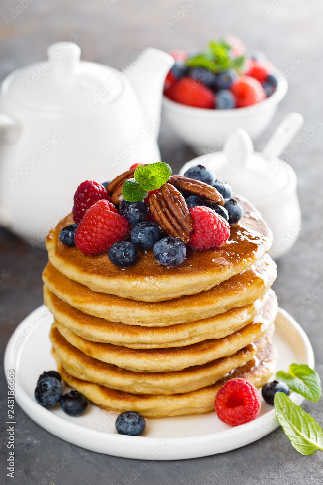 Stack of fluffy pancakes with fresh berries and pecan nuts Stack of fluffy pancakes with fresh berries and pecan nuts