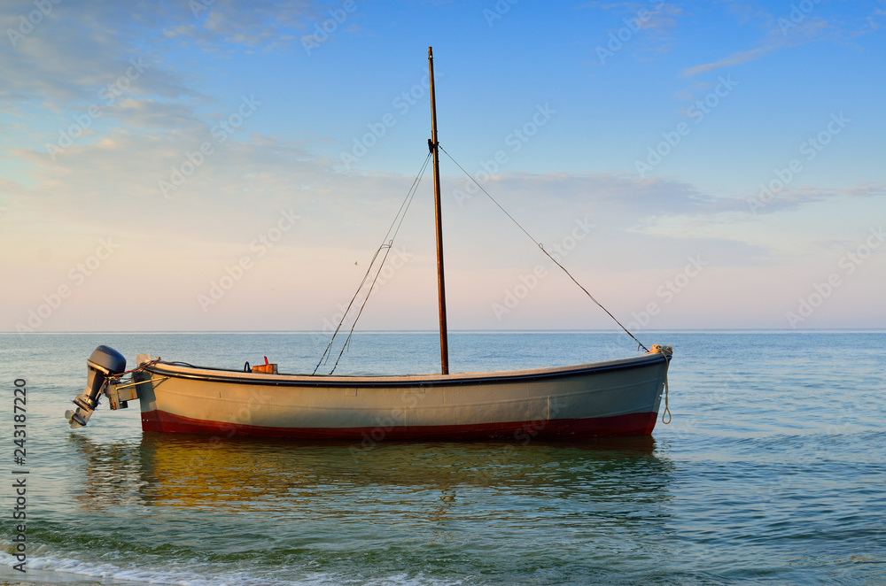 Fototapeta premium Fishing boats moored near the shore at sunset background