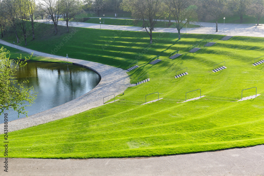 Obraz premium Spring city park with green terrace lawn and staircase