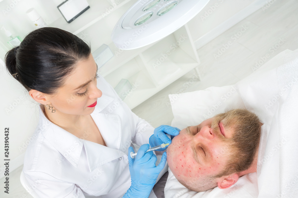 The doctor cosmetologist makes the Rejuvenating facial injections procedure for tightening and smoothing wrinkles on the face skin of a men in a beauty salon.Cosmetology skin care. The doctor cosmetologist makes the Rejuvenating facial injections procedure for tightening and smoothing wrinkles on the face skin of a men in a beauty salon.Cosmetology skin care.