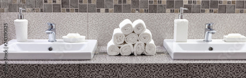 Stack of clean white towels on ceramic countertop in bathroom