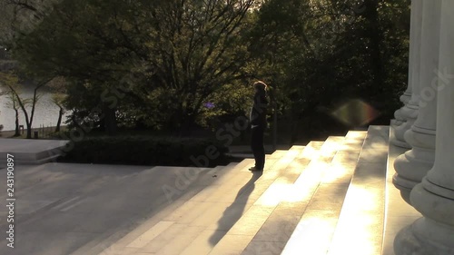 A young lady pensively looks out over the Potomac river from the Jefferson Memorial. Washington, DC is the land of monuments. The capital building sits quietly in the background as the busy capital li