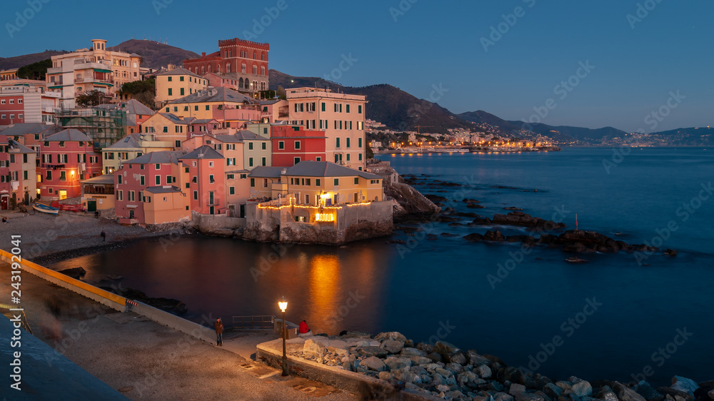 Genoa, Italy. Village of Boccadasse taken at the blue hour on a winter evening. Reflections of the lights on the sea. Boccadasse is an ancient maritime village with pastel shades