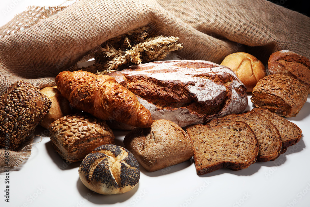 Different kinds of bread and bread rolls on board from above. Different kinds of bread and bread rolls on board from above.