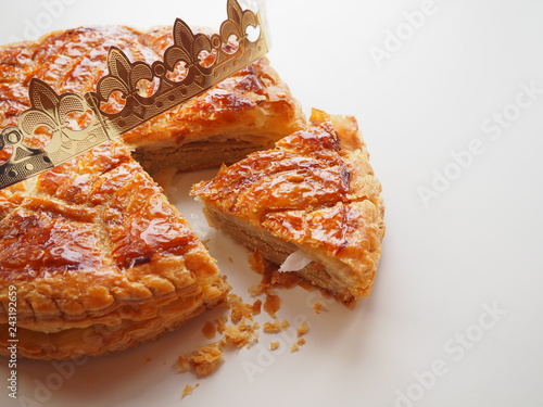 Homemade Epiphany cake or Twelfth Night cake (french galette des rois) made of puff pastry and frangipane (almond cream), white background