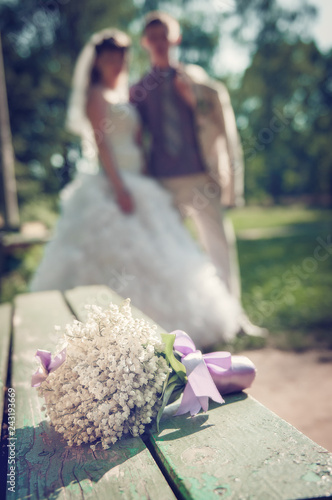 A bride bouquet of lilies of the valley on a green bench. photo